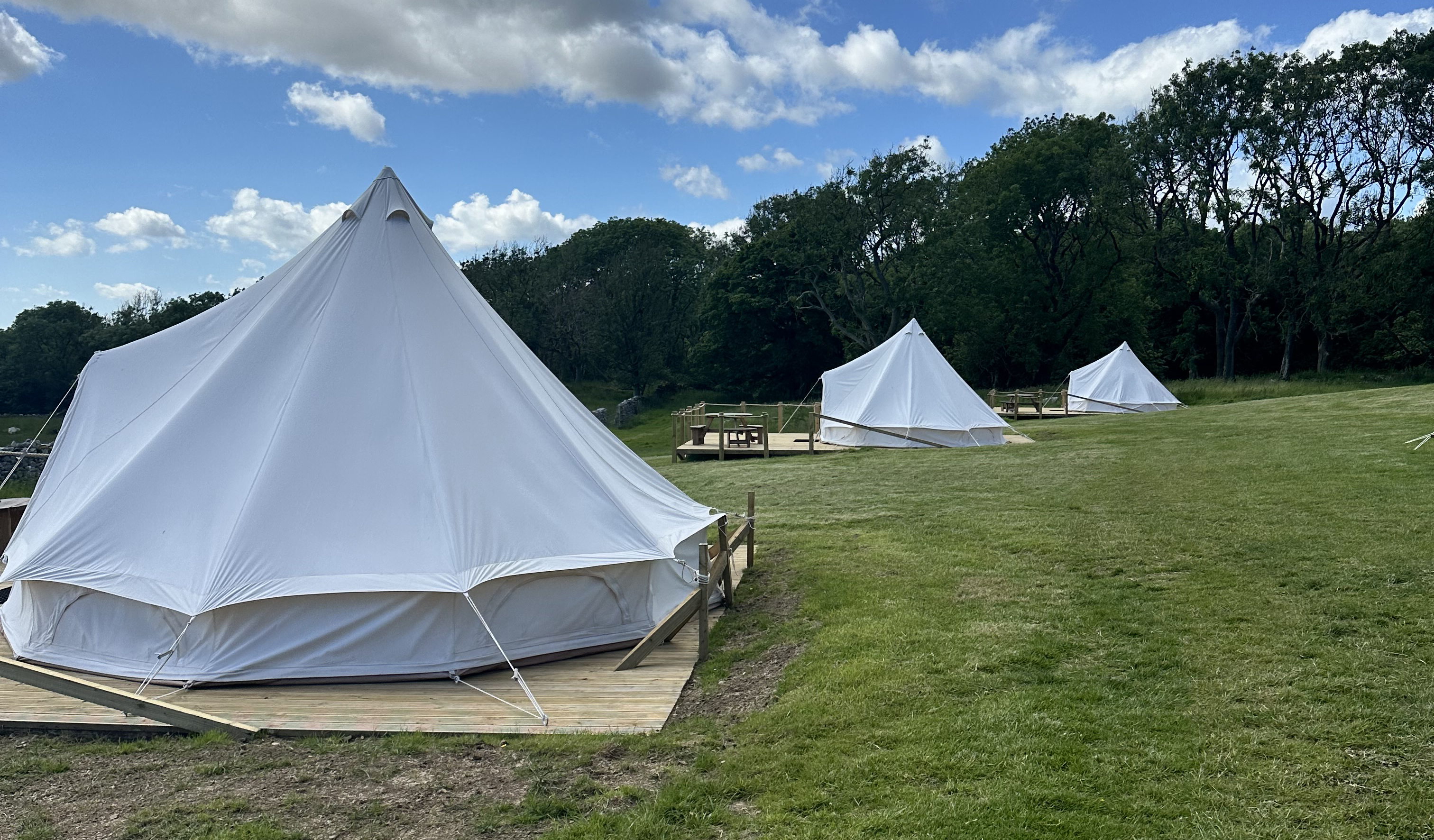 Frontal view of glamping tent with lights and bed at nightfall